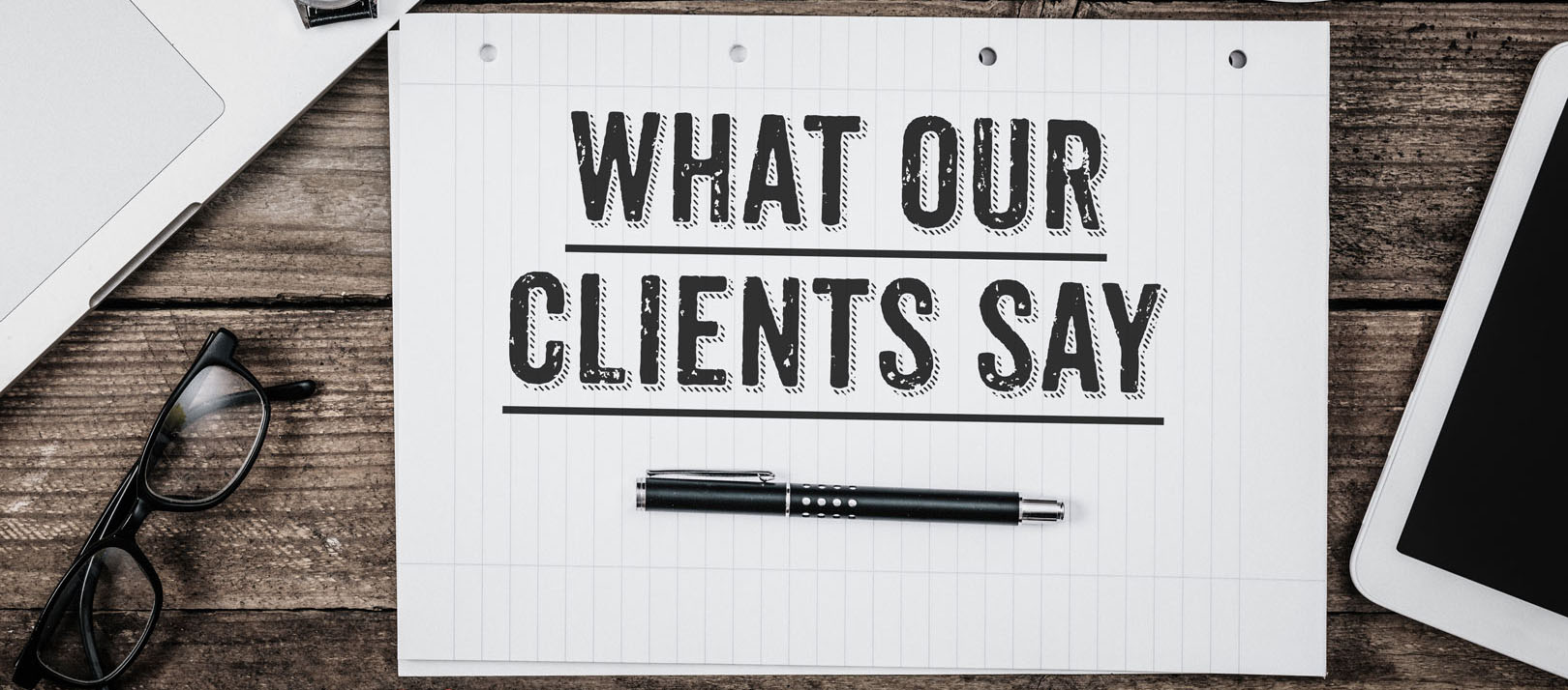 Notepage with 'What Our Clients Say' written on it